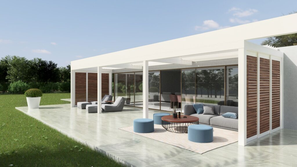 Moderne terrasoverkapping met lamellen en houten zijwanden, geplaatst op een ruim terras met loungehoek, blauwe poefjes en glazen schuifdeuren naar binnen. De witte overkapping zorgt voor een strakke en stijlvolle uitstraling, perfect voor schaduw en privacy in een groene tuin.
